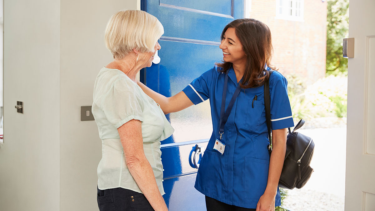 A nurse entering an elderly woman's house for a home visit.