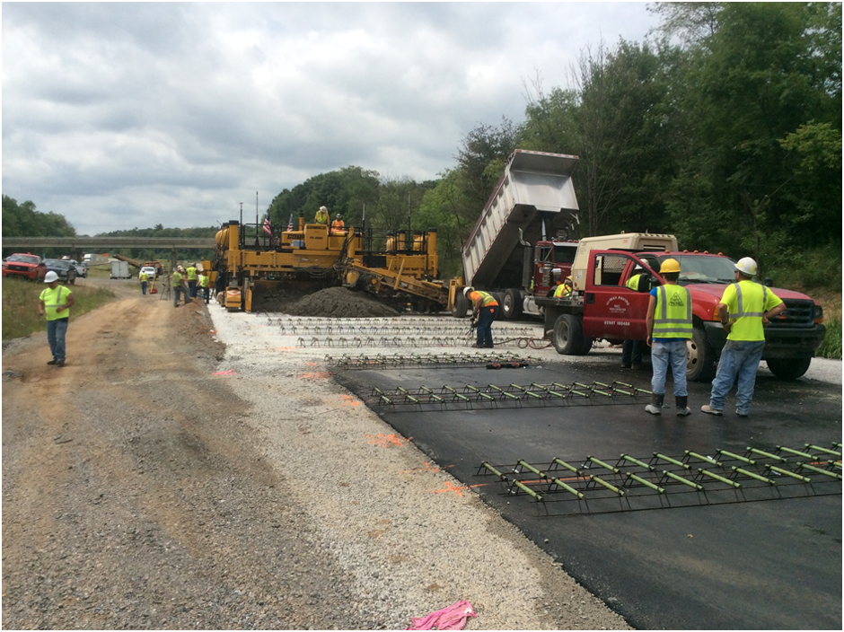 Construction crews placing an overlay on the roadway.