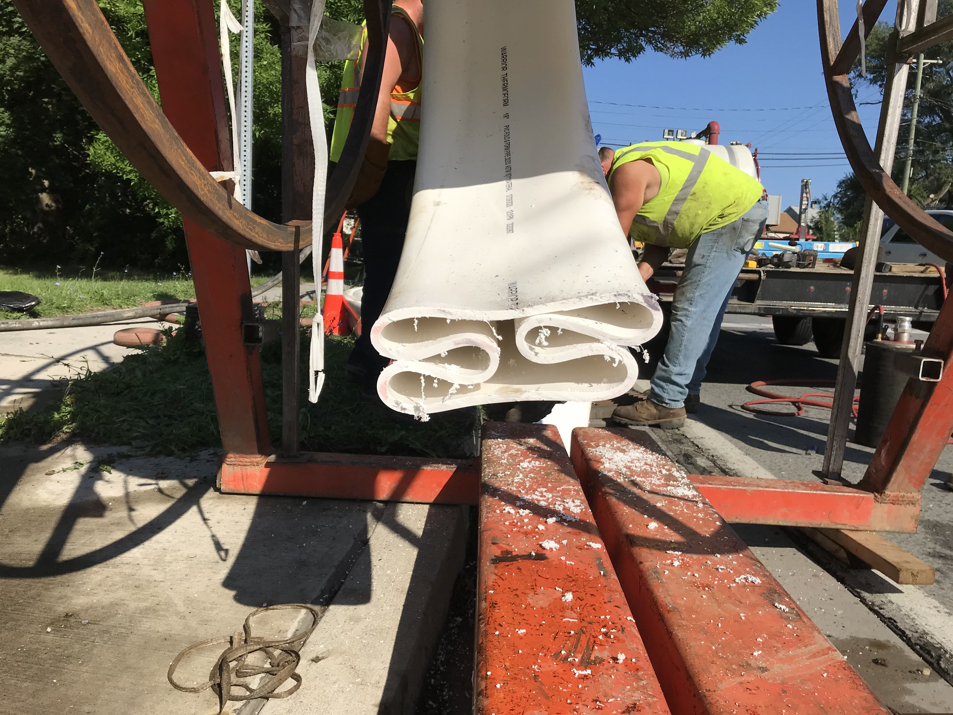 An image of a worker removing a special white PVC liner from a big red metal spool 