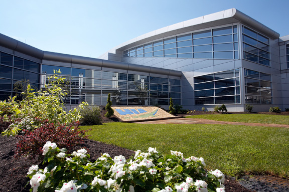 An image of an airport terminal with a large bank of windows and a sign in the grassy area in front of the windows that says HIA for Harrisburg International Airport